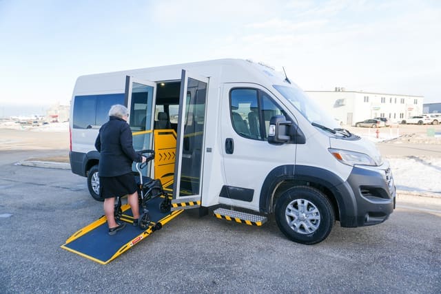 Personne utilisant un déambulateur dans un fourgon à rampe latérale P4 de MoveMobility