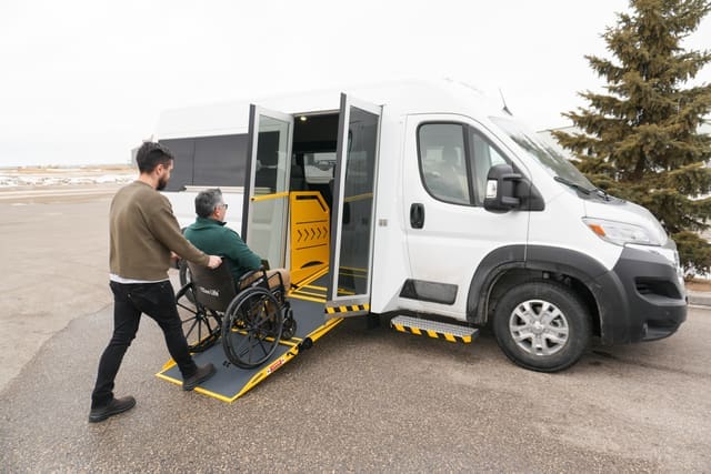 Homme chargeant un utilisateur de fauteuil roulant dans une camionnette MoveMobility P4